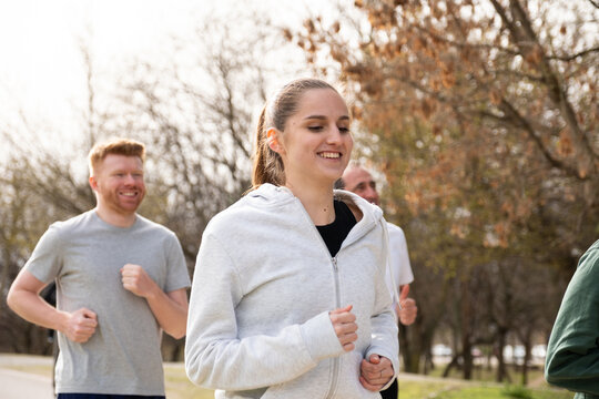 Group of diverse friends running outdoors for fitness and well being