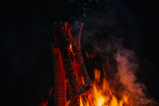 View of burning logs with glowing embers and bright flames in a dark setting in Vormsi, Laane County, Estonia.