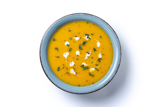 Creamy pumpkin soup isolated on white background. Top view