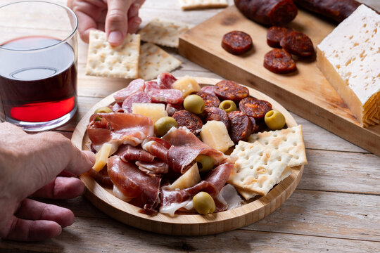 People sharing Spanish charcuterie board with ham, chorizo and cheese