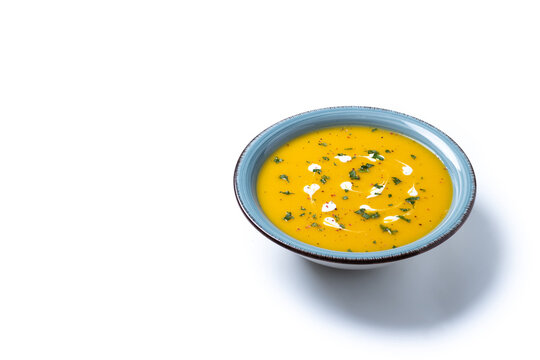 Creamy pumpkin soup isolated on white background. Copy space