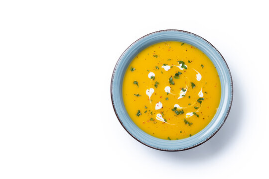 Creamy pumpkin soup isolated on white background. Top view. Copy space