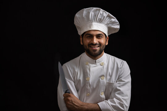 A PROFESSIONAL CHEF HAPPILY POSING IN FRONT OF CAMERA