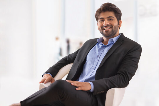 A HAPPY PROFESSIONAL SITTING AND LOOKING AT CAMERA