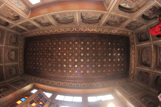 View of the ornate wooden ceiling with intricate geometric patterns and mirror work inside the historic Haveli Nau Nihal Singh in Lahore, Punjab, Pakistan.