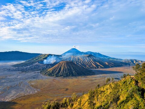 View of Mount Bromo and the surrounding volcanic landscape with steaming craters and rugged terrain in Tosari, East Java, Indonesia.