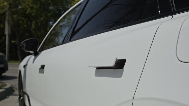 Retractable door handle of modern electric vehicle automatically closing flush into door panel. Perfect for automotive technology commercials and electric vehicle promotions