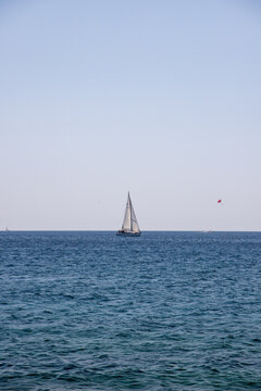 View of a white sailboat sailing on the calm blue Adriatic Sea under a clear sky near Rovinj, Istria County, Croatia.