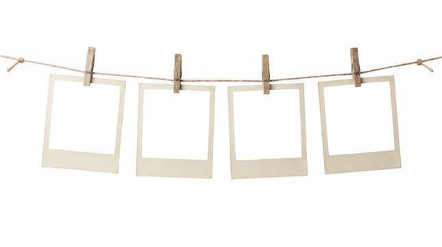 Four empty photo frames hanging on a rope with wooden clips isolated on transparent background