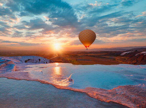 Hot air balloon flying over spectacular pamukkale - Natural travertine pools and terraces in Pamukkale. Cotton castle in southwestern Turkey,