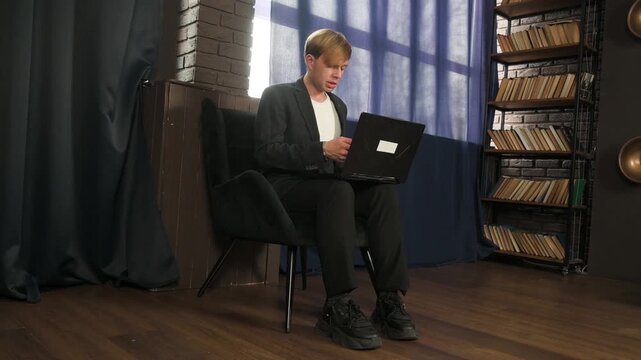 Young Professional Man Working on Laptop in Modern Stylish Home Office or Study Room