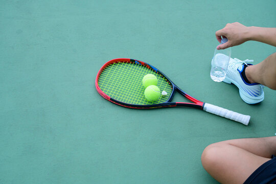 Tennis Player Resting on Court with Racket, Balls and Copyspace