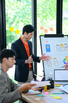 Developer and UI UX Designer Discussing Mobile App Interface Wireframe on Whiteboard in Modern Office