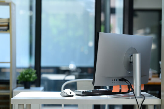 Modern Computer Monitor Back View on Clean White Office Desk with Keyboard and Mouse