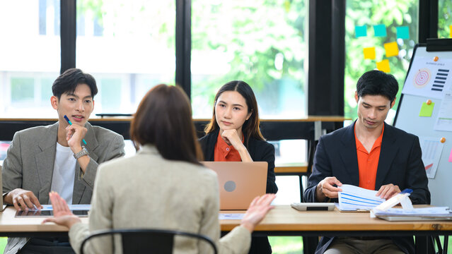 Job Interview Panel with Three Asian Business Professionals Evaluating Female Candidate in Modern Office
