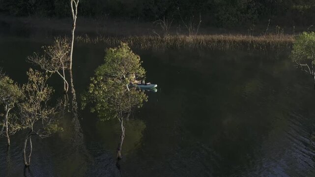Aerial drone view of visitors kayaking and making coffee at sunrise on Suoi Tia, Tuyen Lam Lake in Xuan Huong, Da Lat, Vietnam, enjoying a peaceful morning in nature.