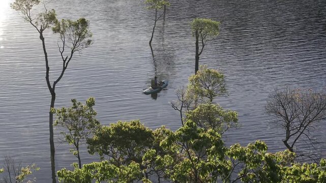 Aerial drone view of visitors kayaking and making coffee at sunrise on Suoi Tia, Tuyen Lam Lake in Xuan Huong, Da Lat, Vietnam, enjoying a peaceful morning in nature.