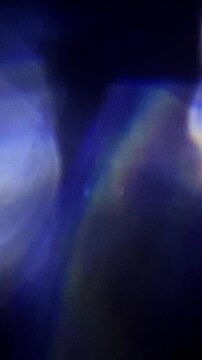 Multicolored real organic light leaks burst overlays film grain show vivid blue flare textures. These abstract glows shine on black background.