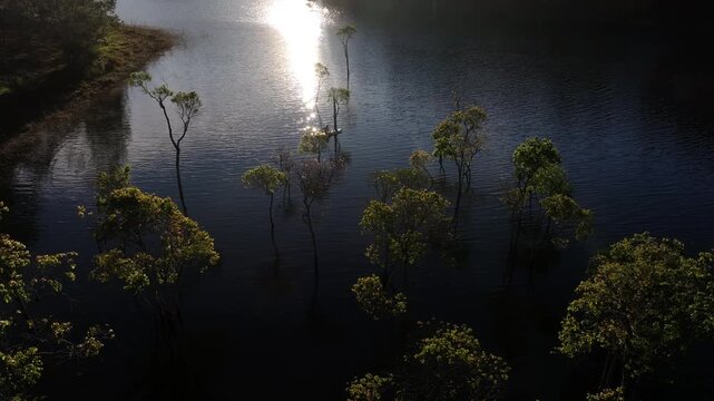 Aerial drone view of visitors kayaking and making coffee at sunrise on Suoi Tia, Tuyen Lam Lake in Xuan Huong, Da Lat, Vietnam, enjoying a peaceful morning in nature.
