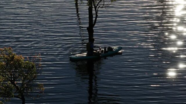 Aerial drone view of visitors kayaking and making coffee at sunrise on Suoi Tia, Tuyen Lam Lake in Xuan Huong, Da Lat, Vietnam, enjoying a peaceful morning in nature.