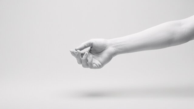 Extended human arm and open hand, monochrome studio shot