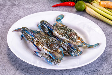 Fresh blue crabs on white plate with lime chili and lemongrass © Andrei Starostin