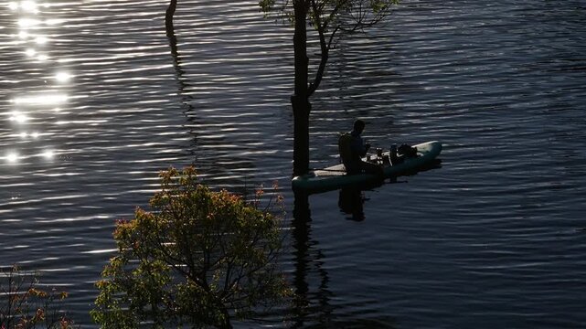 Aerial drone view of visitors kayaking and making coffee at sunrise on Suoi Tia, Tuyen Lam Lake in Xuan Huong, Da Lat, Vietnam, enjoying a peaceful morning in nature.