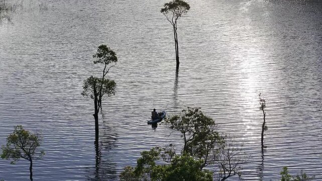 Aerial drone view of visitors kayaking and making coffee at sunrise on Suoi Tia, Tuyen Lam Lake in Xuan Huong, Da Lat, Vietnam, enjoying a peaceful morning in nature.