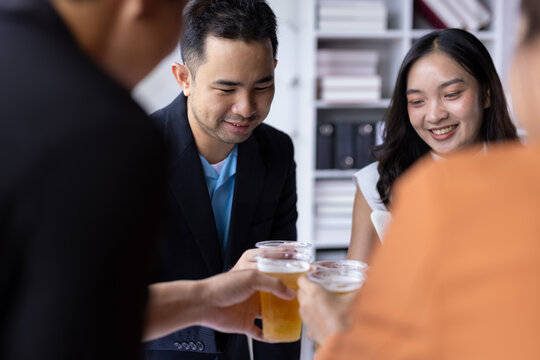 Coworkers toasting drinks celebrating success at office party, celebrating team success and achievement at an office gathering.