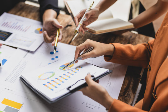 Business people collaborating on data analysis, reviewing charts and graphs during a meeting for financial planning and strategy.