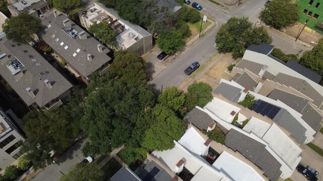 Contrasting multi slope rooflines border tree lined corridors near Oak Lawn Avenue in Dallas. Mounted photovoltaic modules display sustainable housing infill across DFW Metroplex, Texas