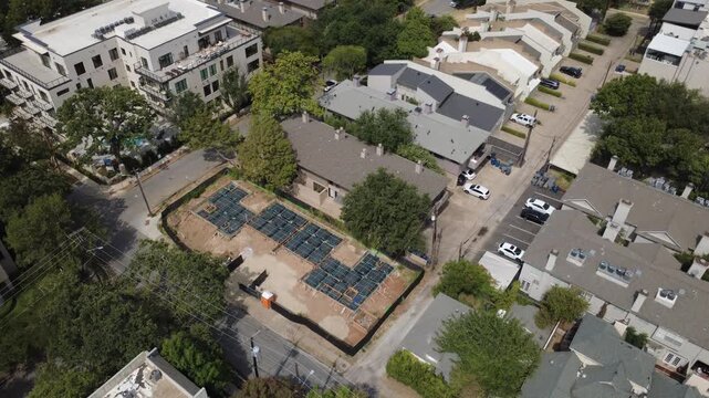 Open excavated parcels sit surrounded by multi tier townhomes along Welborn Street in Dallas. Active ground preparation displays expanding residential infill, DFW Metroplex, Texas