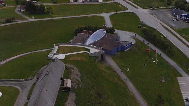 Aerial view showing the Lofotr Viking Museum complex, traditional longhouse reconstruction, walkways, and grassy hills in Borg, Lofoten, Norway.