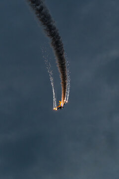 View of an aerobatic plane performing a maneuver with smoke trails and pyrotechnics during the Antidotum Airshow at Leszno Airport, Leszno, Wielkopolskie, Poland.