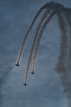 View of three propeller planes performing aerobatic maneuvers with smoke trails at the Antidotum Airshow at Leszno Airport, Leszno, Wielkopolskie, Poland.