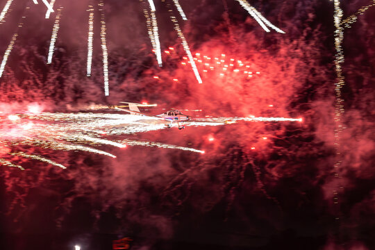 View of a small aircraft performing a night aerobatic display with pyrotechnic trails at the Antidotum Airshow at Leszno Airport, Leszno, Wielkopolskie Voivodeship, Poland.