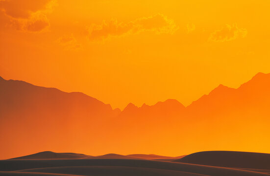 View of sand dunes at sunset with mountains in the background in Death Valley, California, United States.