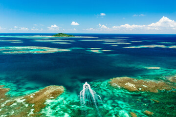 Aerial View of Ferry Navigating Coral Reef Towards Ogami Island © YUTAKA
