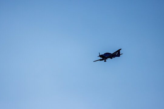 View of a small propeller aircraft flying against a clear blue sky in Vilnius, Vilniaus apskritis, Lithuania.