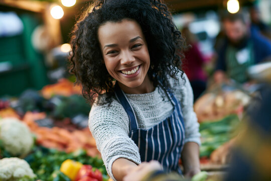 Cheerful Woman Serving Customer at Farmers Market Stall