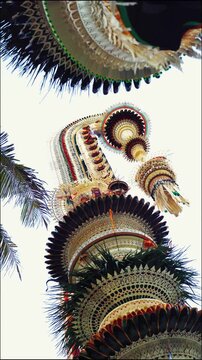 Tall decorative bamboo pole penjor erected for Galungan Hindu festival along street, Bali, Indonesia