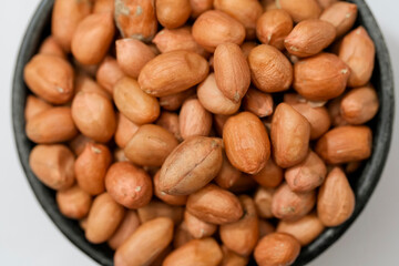 Obraz premium Raw peanut kernels in brown peel in close-up White Background