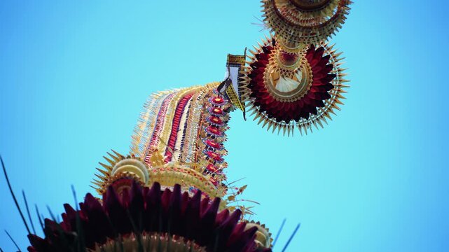 Tall decorative bamboo pole penjor erected for Galungan Hindu festival along street, Bali, Indonesia
