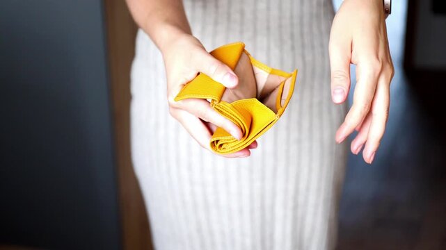 Close-up of female hands that put small change cash into an open leather wallet. Inflation, crisis and low income concept.