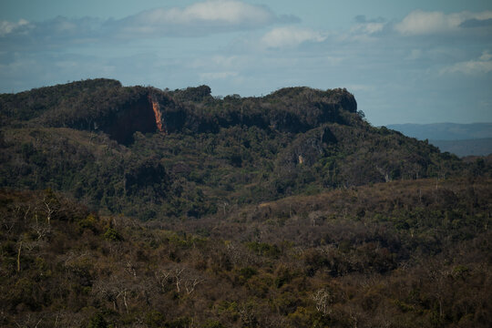 View of French Mountain featuring rugged rocky cliffs, dense dry forest vegetation, and rolling hills in Antsiranana, Diana, Madagascar.