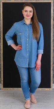 Young woman in casual denim outfit standing in front of a blackboard