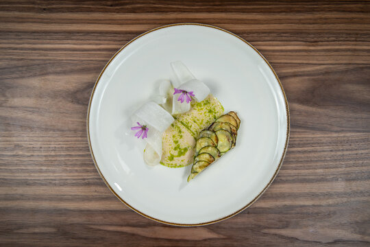 Grilled zucchini rolls served with fresh mozzarella and herb sauce, food flat lay, top-view on a wooden table