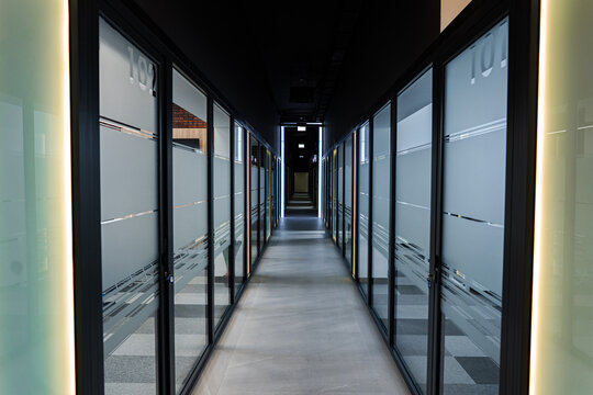 Empty corporate hallway showing frosted glass panels and sleek architectural design