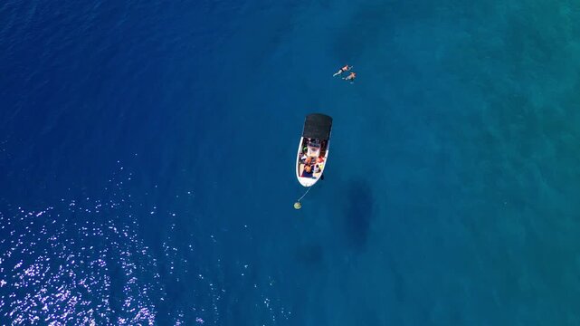 A group of friends enjoys a leisurely boat ride in the crystal-clear waters of the adriatic sea, surrounded by vibrant blue beaches and turquoise waves.