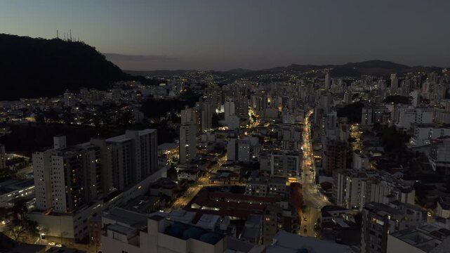 Panoramic Urban Skyline at Dusk Beneath Dark Mountain Horizon